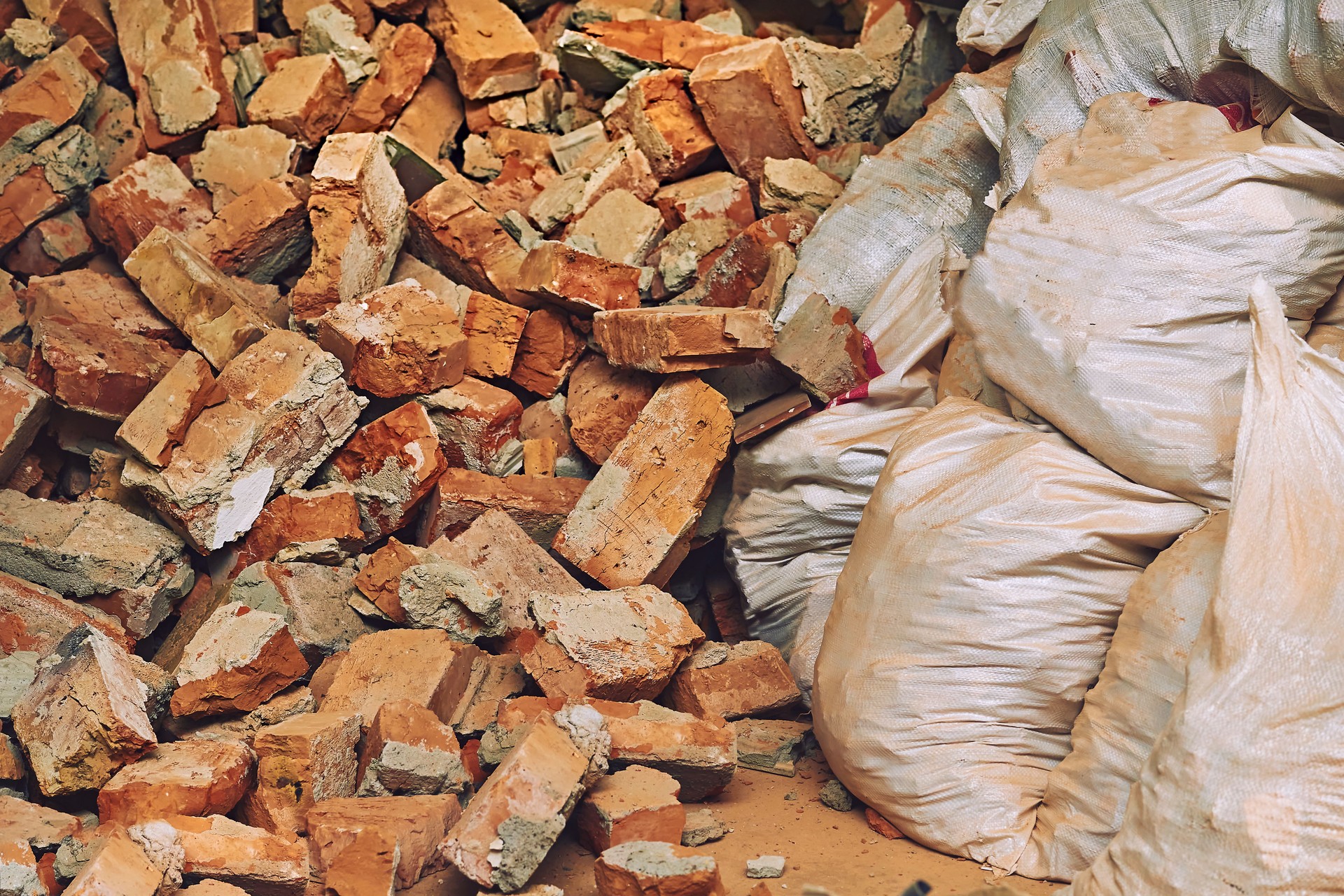 Basura rota en bolsas. Una pila de fragmentos de ladrillo rojo. Limpieza y reparación