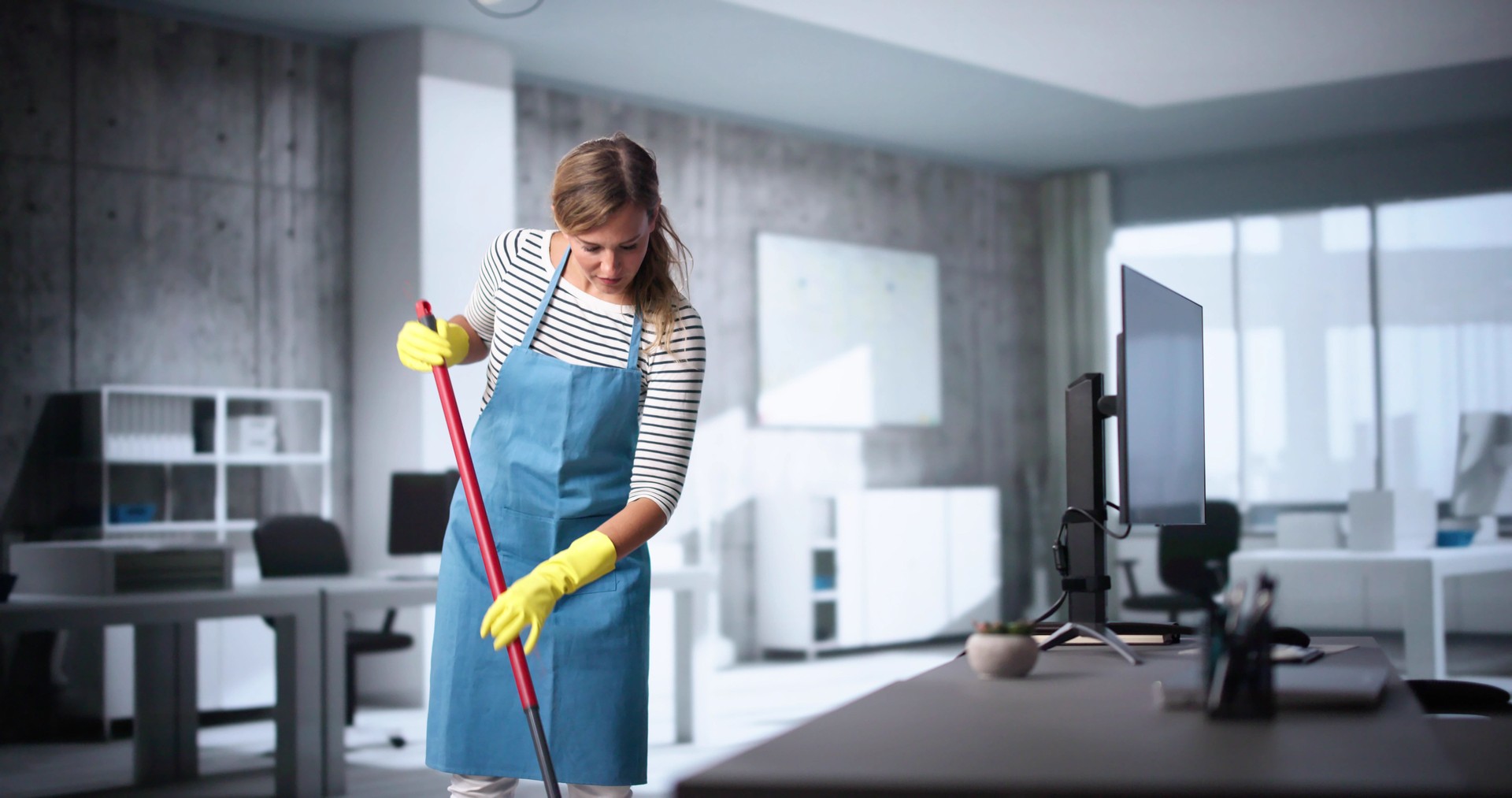 Female Janitor With Mop Cleaning Modern Office